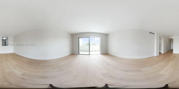 a view of a big room with wooden floor and windows