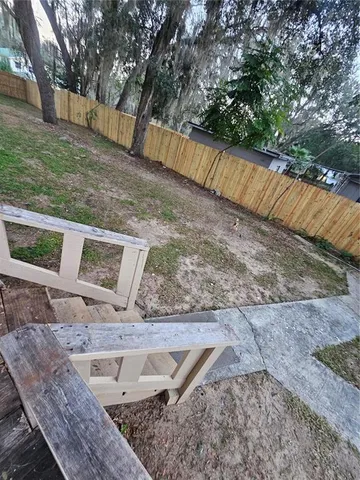 a view of a yard with wooden fence