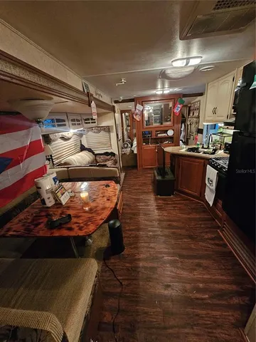 a room with lots of wooden furniture and a view of kitchen