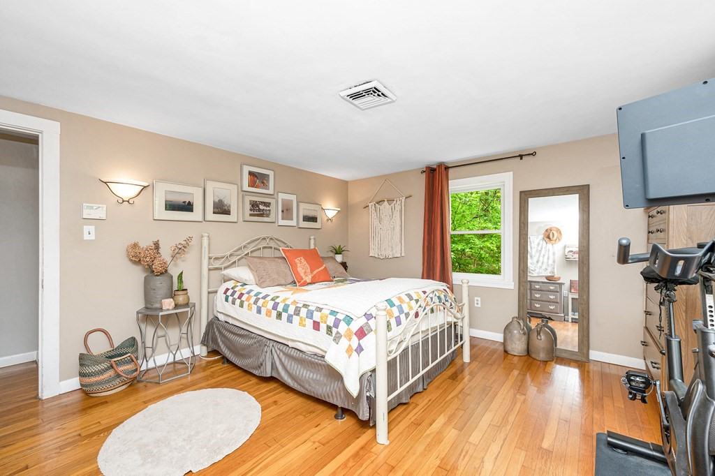 222 Gates Pond Road Berlin, MA 01503 - Photo 13 of 36 a bedroom with a bed and a flat tv screen on the dresser