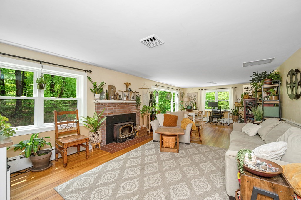 222 Gates Pond Road Berlin, MA 01503 - Photo 4 of 36 a living room with furniture fireplace and a floor to ceiling window