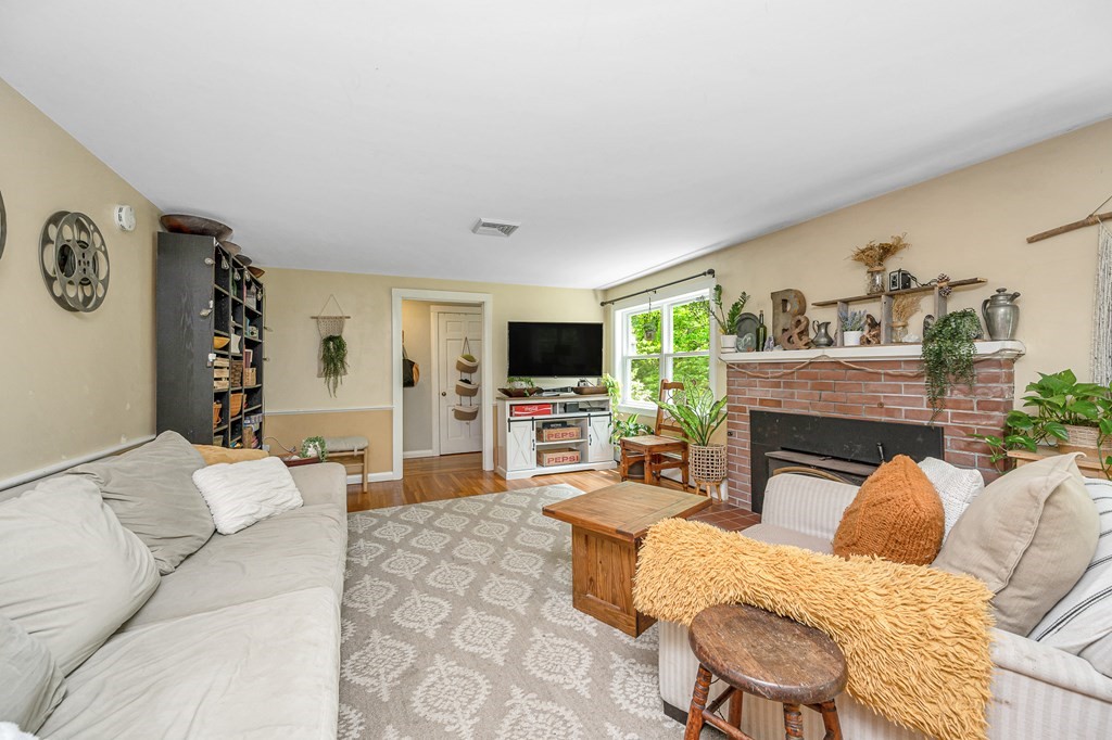 222 Gates Pond Road Berlin, MA 01503 - Photo 5 of 36 a living room with furniture a flat screen tv and a fireplace