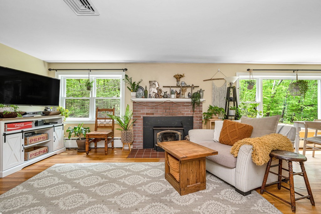 222 Gates Pond Road Berlin, MA 01503 - Photo 6 of 36 a living room with furniture a flat screen tv and a fireplace