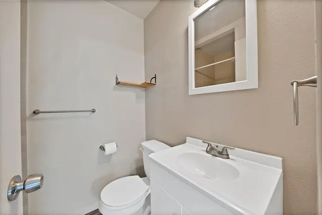 a bathroom with a sink toilet and mirror