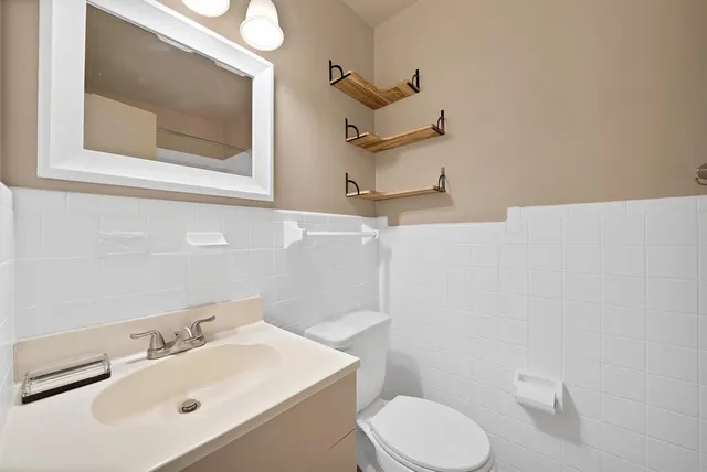 a bathroom with a sink mirror and toilet