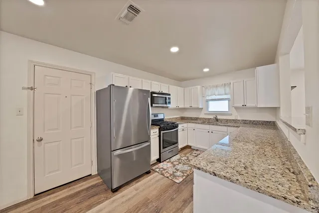 a kitchen with refrigerator and cabinets
