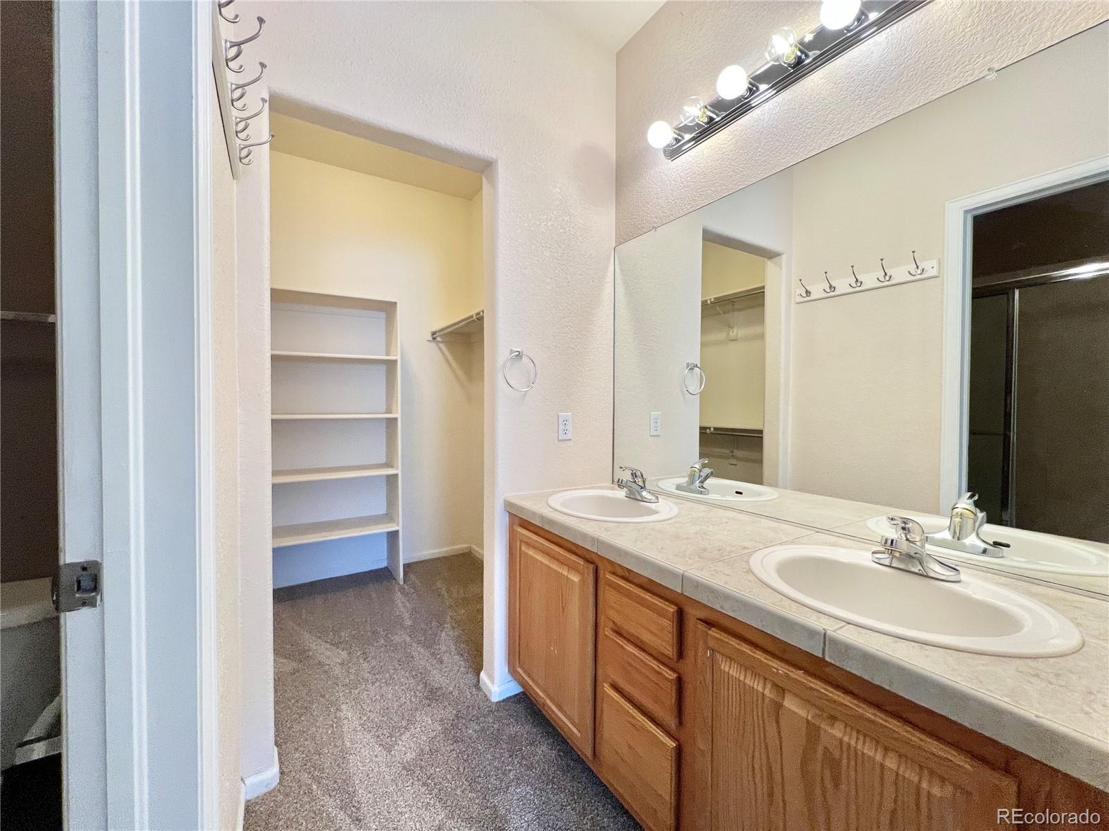 1385 South Chambers Road, Unit 102 Aurora, CO 80017 - Photo 12 of 20 a bathroom with a sink double vanity and a mirror