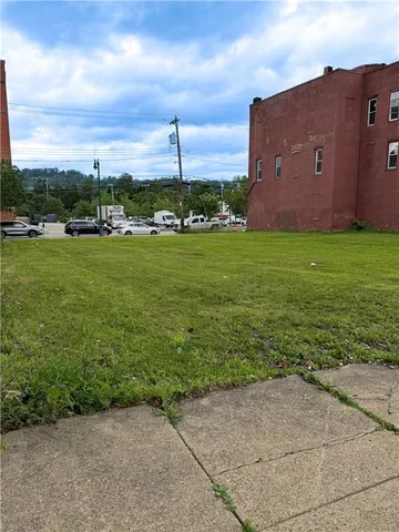 a view of a big yard with a building in the background