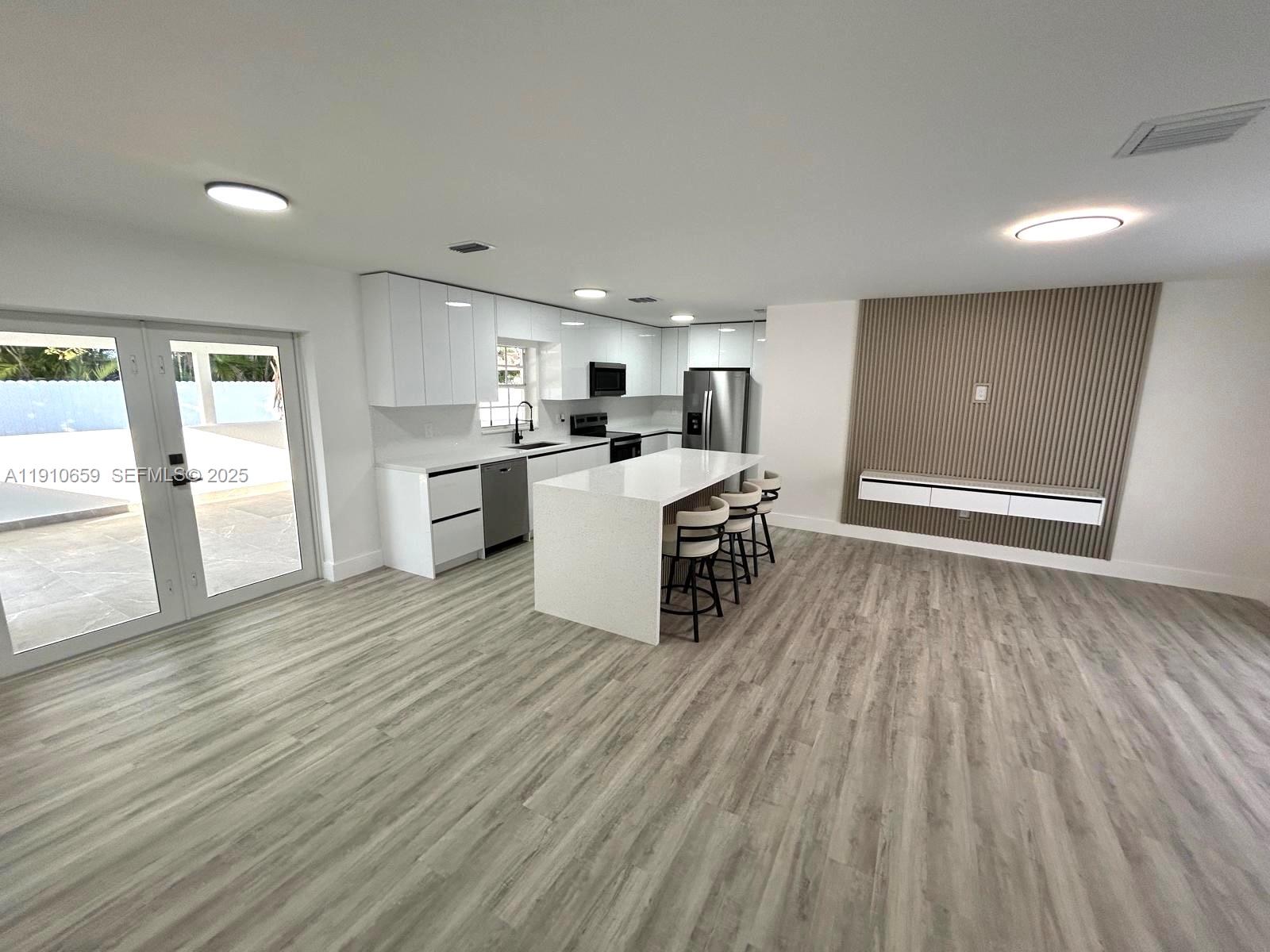 14211 Southwest 286th Street Homestead, FL 33033 - Photo 17 of 38 a open kitchen with cabinets wooden floor and stainless steel appliances