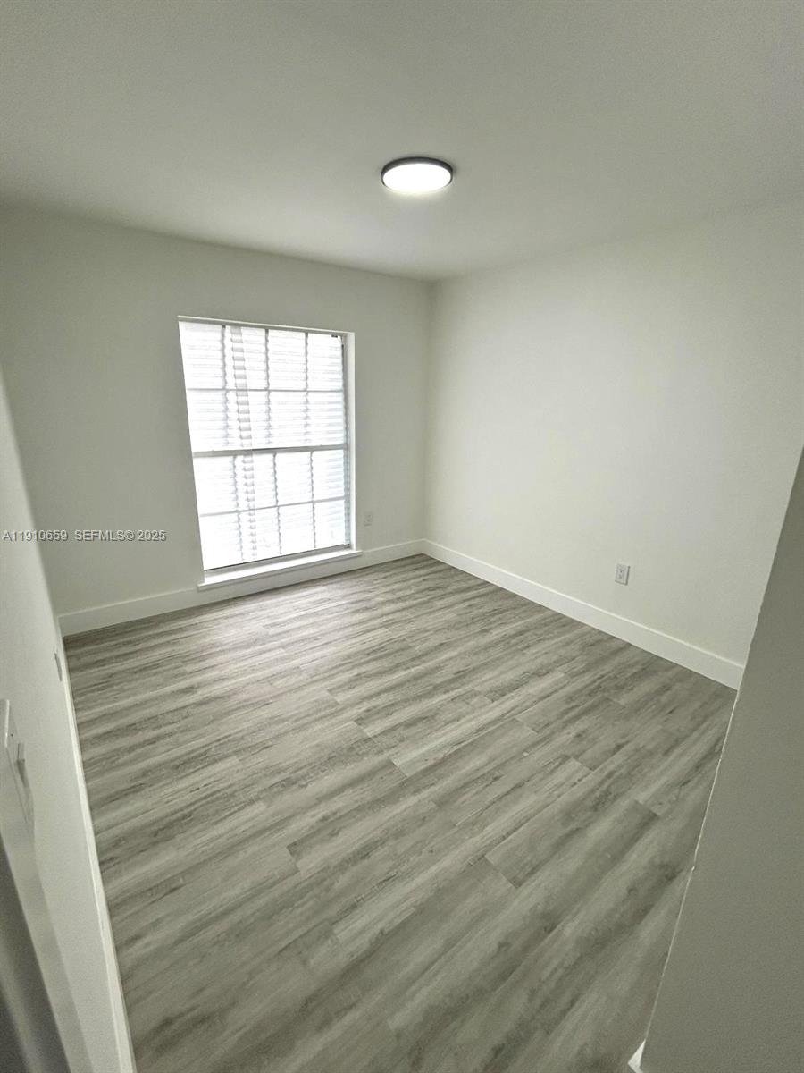 14211 Southwest 286th Street Homestead, FL 33033 - Photo 23 of 38 an empty room with wooden floor and windows