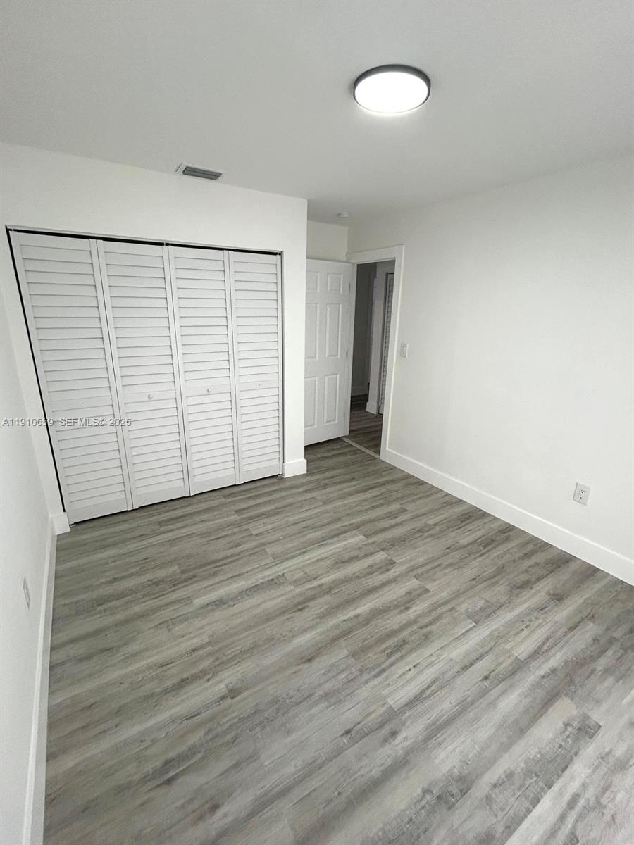 14211 Southwest 286th Street Homestead, FL 33033 - Photo 24 of 38 an empty room with wooden floor and windows