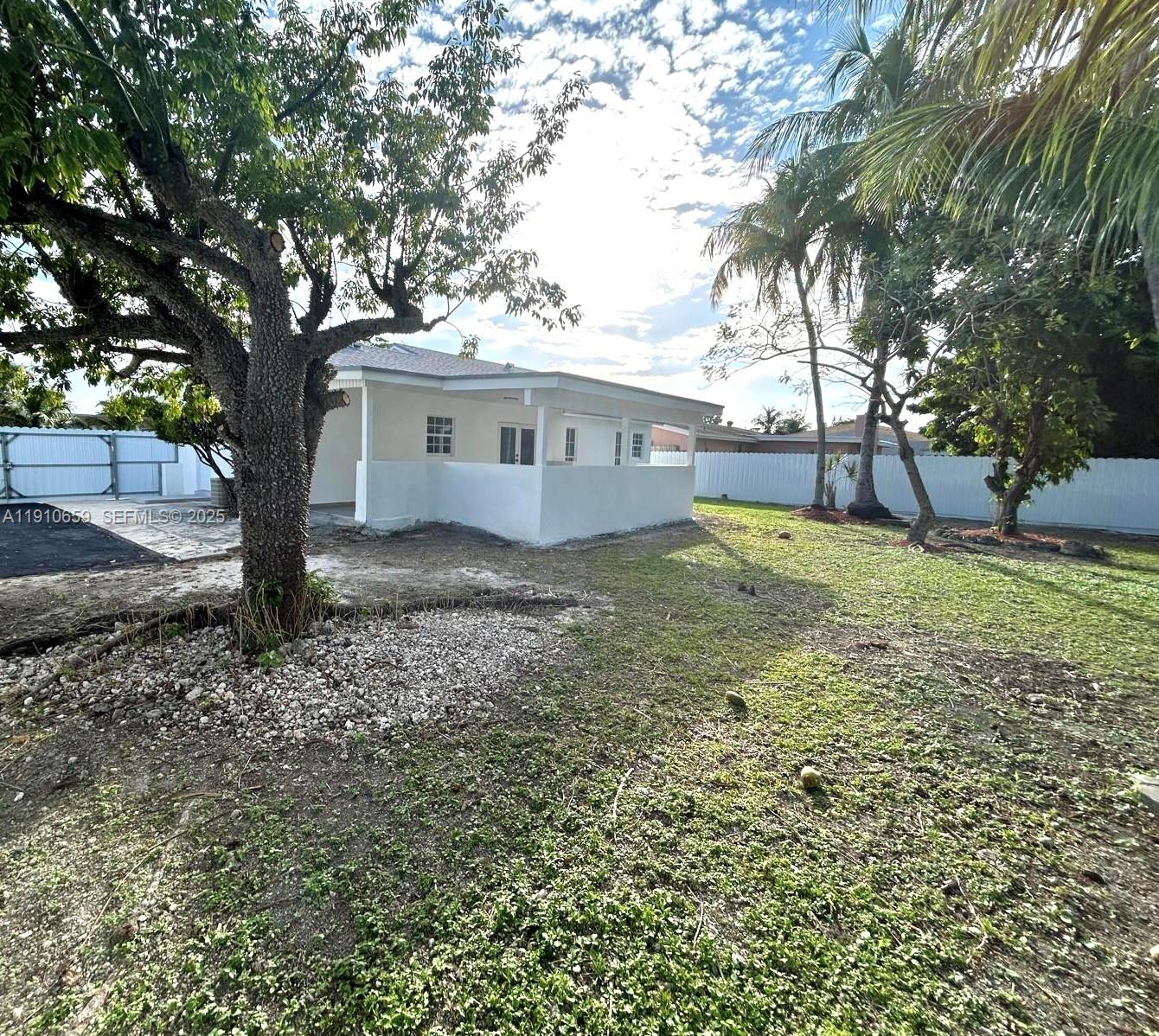 14211 Southwest 286th Street Homestead, FL 33033 - Photo 34 of 38 a view of a house with a tree and a yard