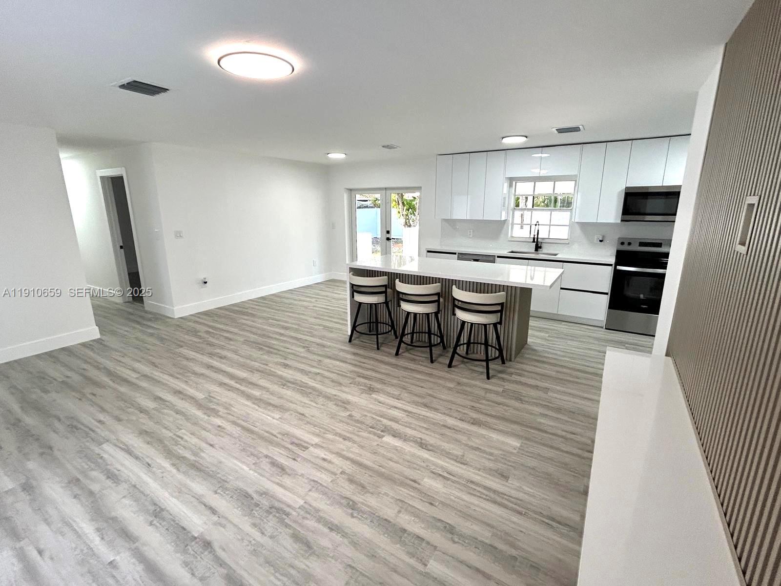 14211 Southwest 286th Street Homestead, FL 33033 - Photo 10 of 38 a view of a kitchen with dining room and wooden floor
