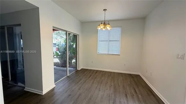 an empty room with wooden floor and window