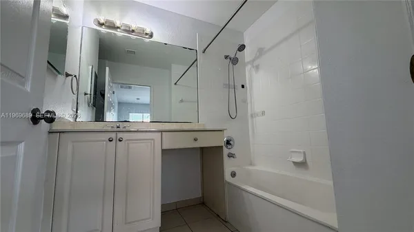 a bathroom with a tub a sink and mirror