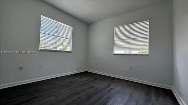 an empty room with wooden floor and a window