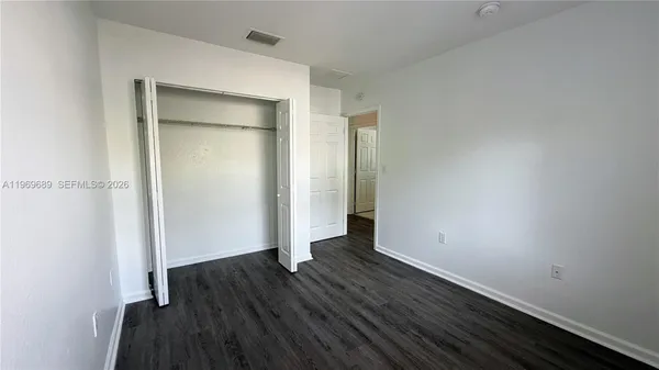 an empty room with wooden floor and closet