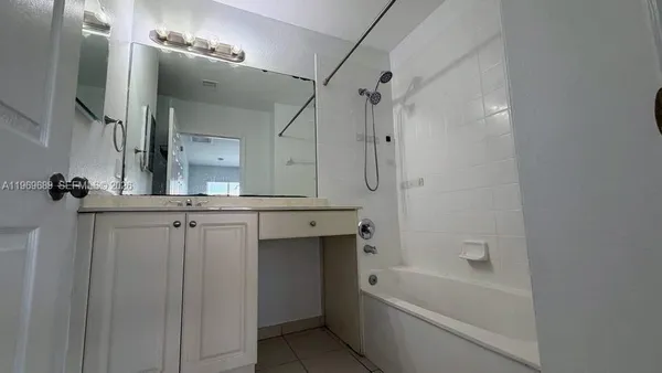 a bathroom with a bathtub a sink a vanity and a mirror