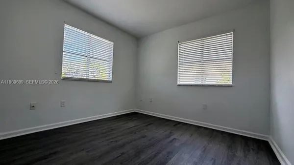 an empty room with wooden floor and a window
