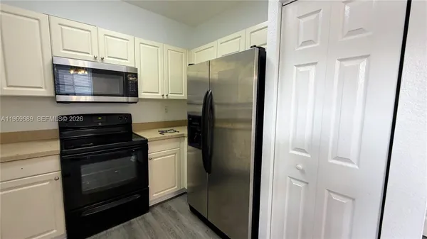 a kitchen with stainless steel appliances granite countertop a refrigerator stove and sink