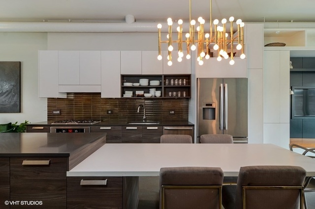 2811 West Shakespeare Avenue Chicago, IL 60647 - Photo 6 of 20 a kitchen with a chandelier a refrigerator and cabinets