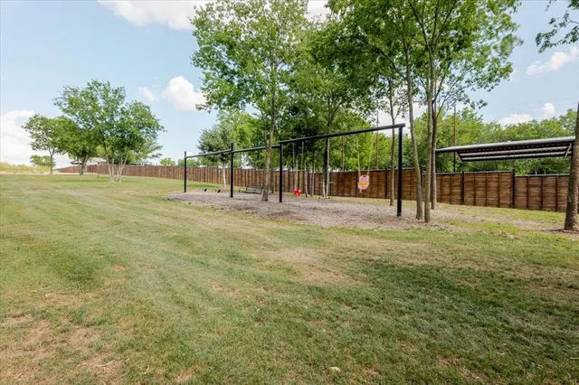 a view of a yard with a slide and large trees