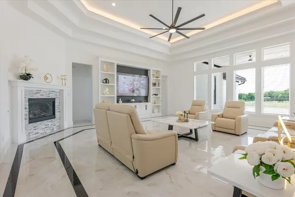 a living room with furniture fireplace and a large window