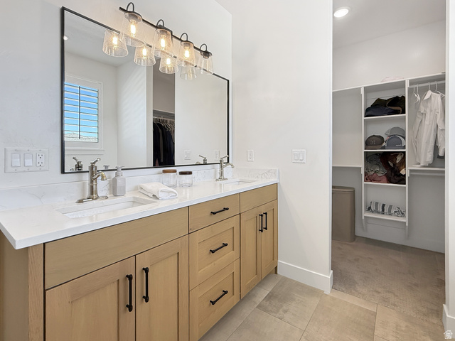 916 Rocky Mountain Way Elk Ridge, UT 84651 - Photo 25 of 54 Bathroom with a spacious closet, double vanity, recessed lighting, light carpet, and light tile patterned floors