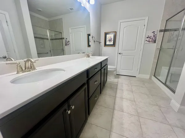 a bathroom with a double vanity sink a toilet and a mirror