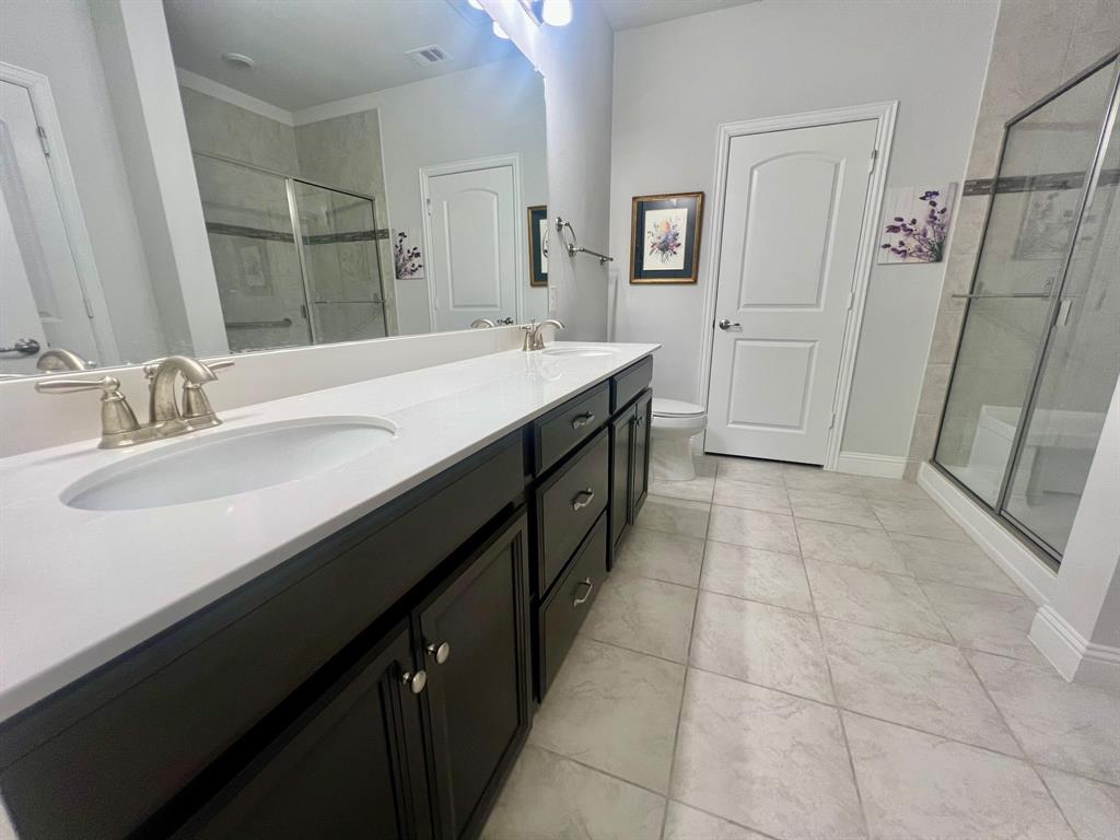 651 Watters Road, Unit 7101 Allen, TX 75013 - Photo 11 of 25 a bathroom with a double vanity sink a toilet and a mirror