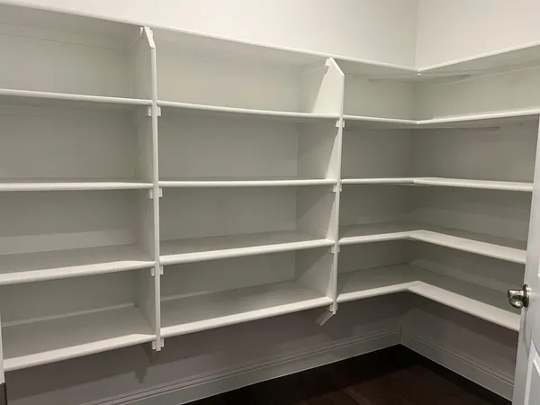 a view of walk in closet with empty racks
