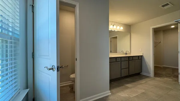 an empty room with closet and a bathroom