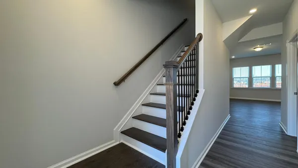 an entryway in a hall with a window and wooden floor