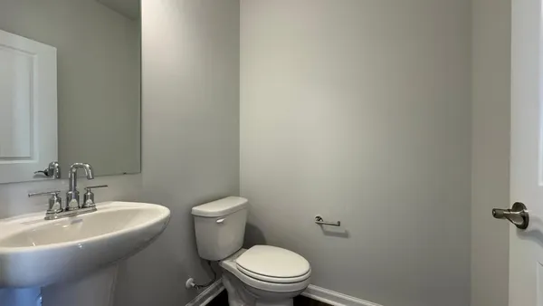 a white toilet sitting next to a bathroom sink