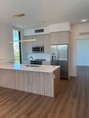 a kitchen with stainless steel appliances a refrigerator and a stove top oven