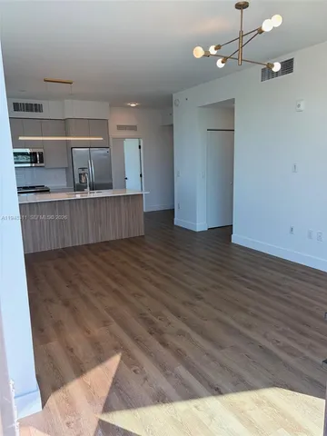a view of a room with wooden floor and ceiling fan