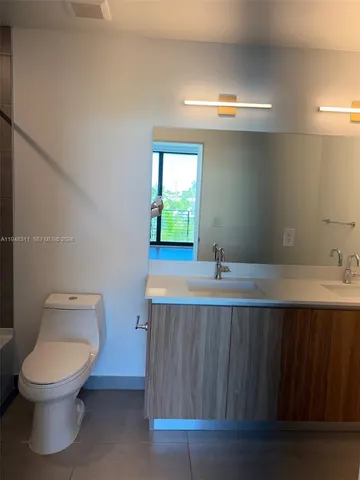 a bathroom with a sink a toilet and mirror