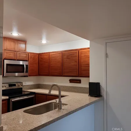 a kitchen with a sink and a stove top oven with wooden floor