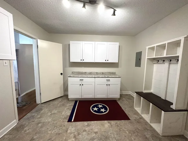 a view of entryway with microwave and cabinets
