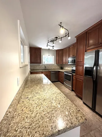 a kitchen with stainless steel appliances granite countertop a refrigerator sink and cabinets