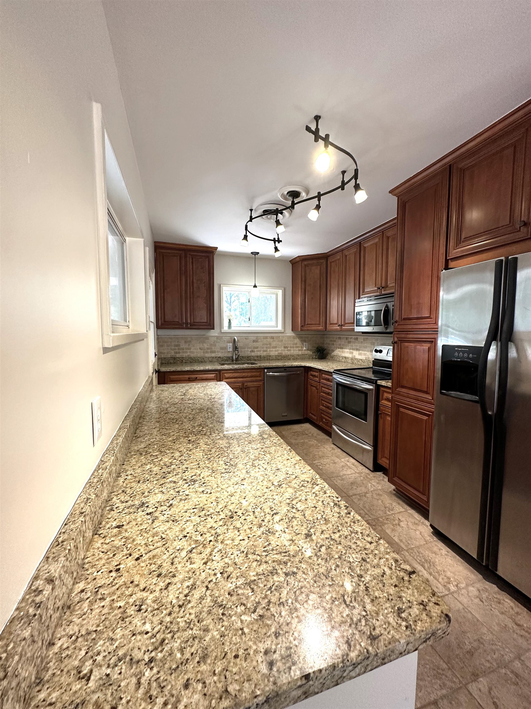 5260 Brantford Avenue Memphis, TN 38120 - Photo 7 of 23 a kitchen with stainless steel appliances granite countertop a refrigerator sink and cabinets