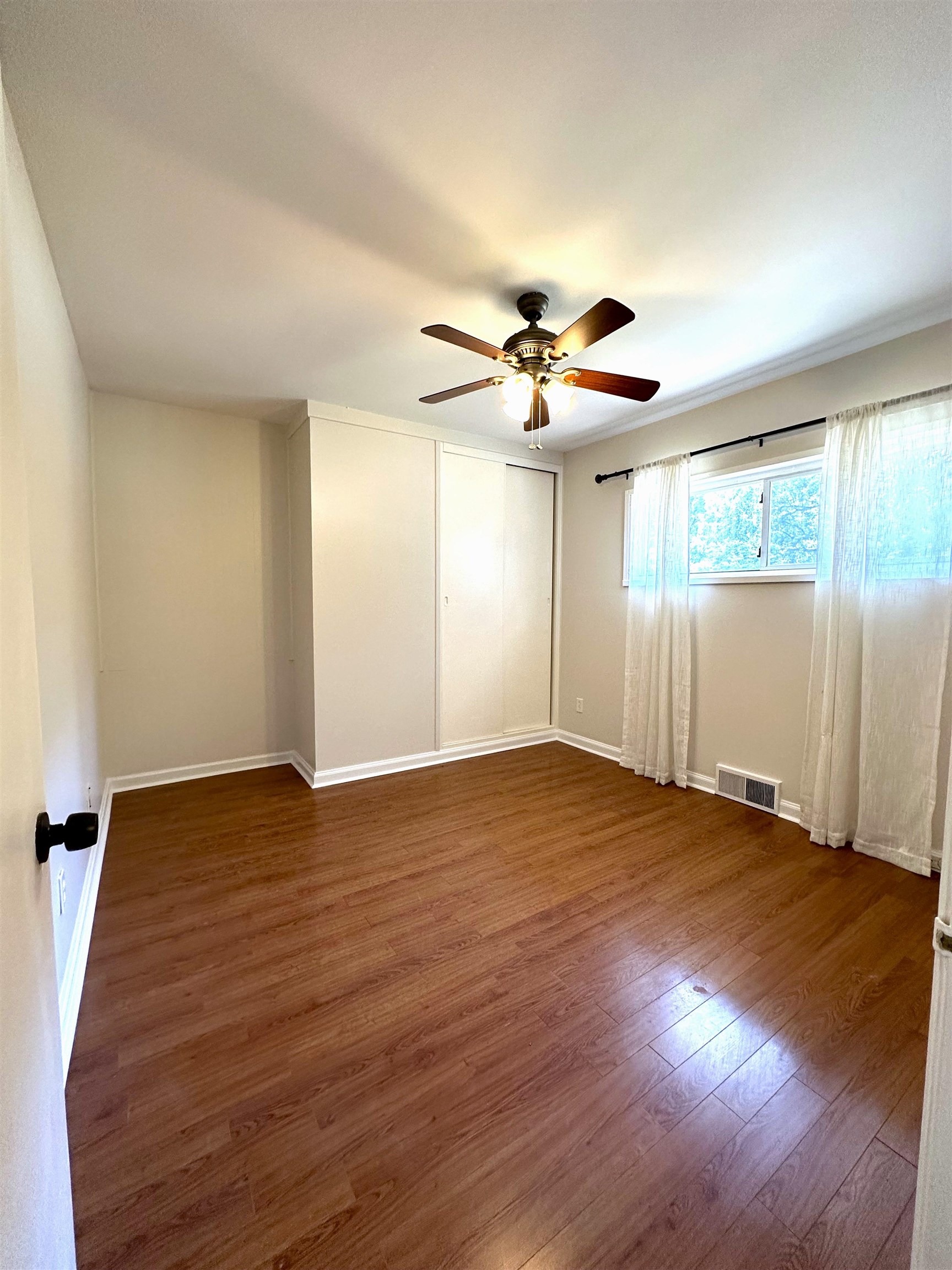 5260 Brantford Avenue Memphis, TN 38120 - Photo 8 of 23 a view of an empty room with wooden floor and a window