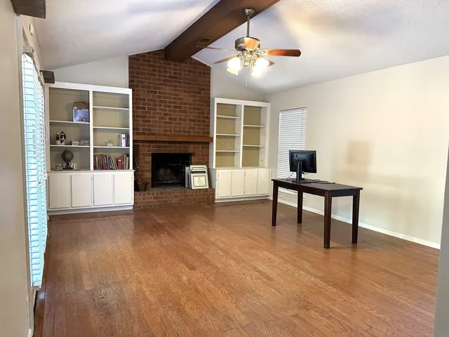 a view of a livingroom with a fireplace and workspace