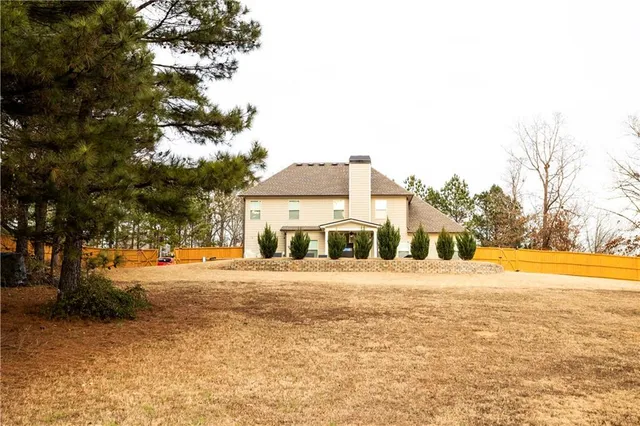 a front view of a house with a yard and trees