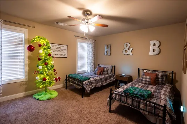 a bedroom with three beds and a chandelier