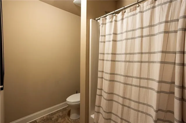 a bathroom with a toilet and a shower curtain