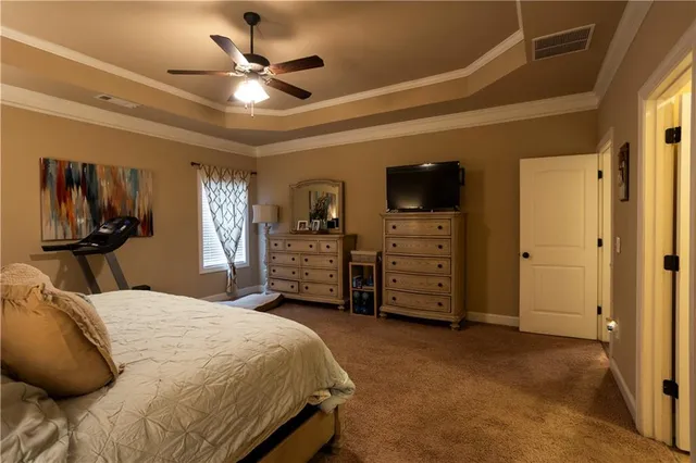 a bedroom with a bed a dresser and a chandelier