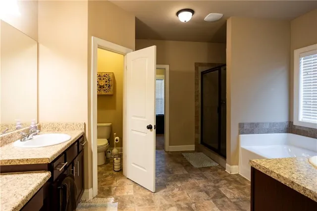 a spacious bathroom with a granite countertop sink and a mirror