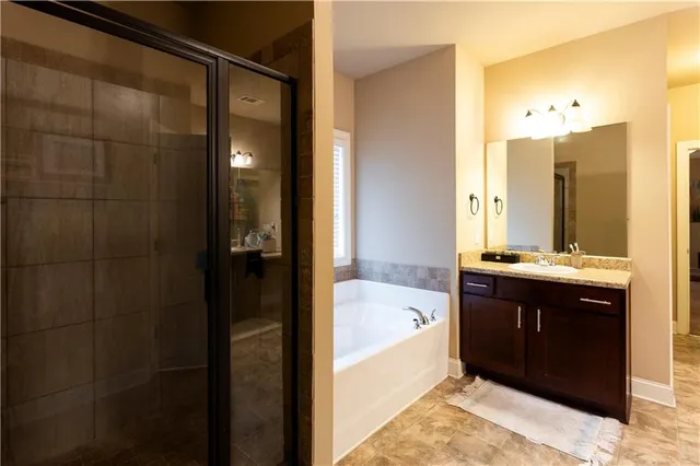 a bathroom with a tub sink shower and mirror