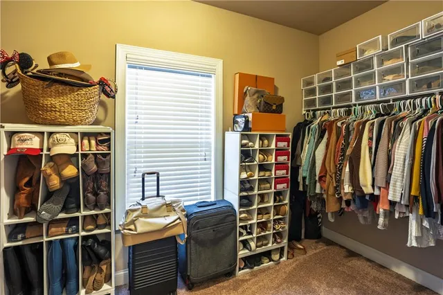 a view of walk in closet with clothes and shoes